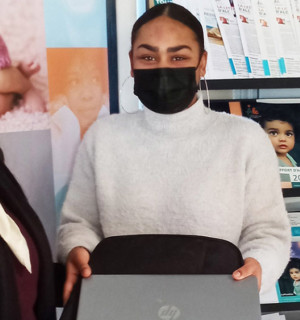 Une jeune bénéficiaire du coup de pouce ayant eu don d'un ordinateur